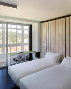 Un pat sau paturi într-o cameră la Moure Hotel