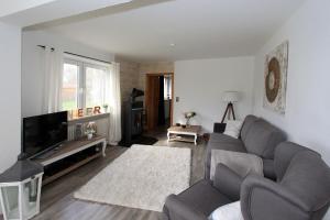 a living room with a couch and a tv at Ferienwohnung Strandgut in Behrensdorf