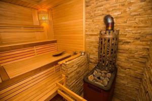 a sauna with a heater in the corner of a room at Tartak Resort in Pasiky-Zubryts'ki