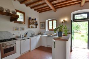 a kitchen with white cabinets and a stove at Fattoria il Leccio Independent Apartment on Florence Hills in Fiesole