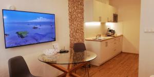 a kitchen with a table and a television on a wall at Apartmány Cechovní in Moravská Třebová