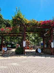 a pergola with flowers on it in a park at Casa de Férias no Porto das Dunas in Aquiraz