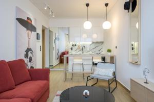 salon z czerwoną kanapą i stołem w obiekcie MadaM Apartments - elegant, cozy, comfortable, central w mieście Janina