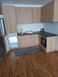 a kitchen with wooden cabinets and a black counter top at Apartman" AROMA 2 "Bjelasnica in Bjelašnica