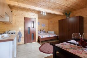 a kitchen and a bedroom with a bed in a room at Domki Leśny Zakątek in Pogorzelica