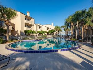 a swimming pool in a courtyard with palm trees at Spinnaker's Reach 704, Ocean View Pool, 3 Bedroom, Sleeps 8 in Ponte Vedra