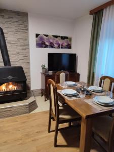 a dining room with a table and a fireplace at Apartman Adna in Kulen Vakuf