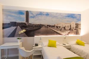 a room with two beds and a picture of a river at Bilbao City Rooms in Bilbao