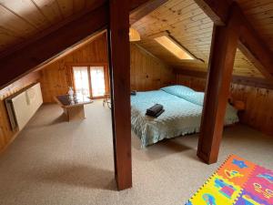 um quarto com uma cama num sótão de madeira em Harmony House em Salvan