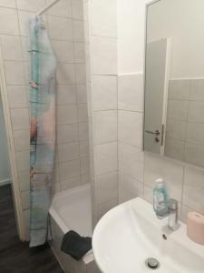 ein Badezimmer mit Waschbecken und Duschvorhang in der Unterkunft Apartment Cologne in Köln