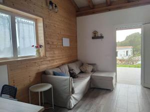 sala de estar con sofá y ventana en Casa de madera El jardín de Tara, en Tiñor