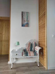 un banco blanco con una lámpara en una habitación en Casa de madera El jardín de Tara, en Tiñor