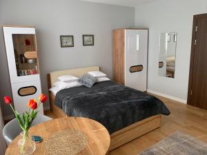 ein kleines Schlafzimmer mit einem Bett und einem Tisch in der Unterkunft Apartament Perłowy in Zamość