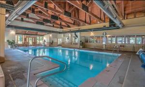 a large indoor swimming pool with blue water at Sun & Snow Chalet Breckenridge, a dog lovers dream! in Breckenridge