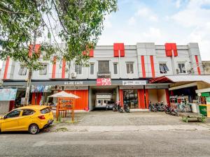 a yellow car parked in front of a building at Super OYO 90927 Homestay Tentrem 2 in Pati