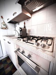 kuchnia z kuchenką i osoba stojąca za nią w obiekcie Welcome Traveller L'APPARTAMENTO DI NORMA w mieście Bardolino