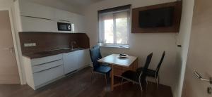a small kitchen with a small table and chairs at Apartments Barbic in Medulin