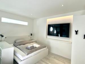 a bedroom with a bed and a flat screen tv at Apartment Schloofschdubb in Fuldatal bei Kassel in Fuldatal