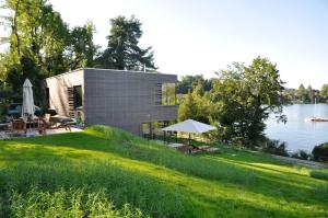 mały domek na trawniku obok jeziora w obiekcie SEE 31, Ferienlofts am Traunsee w mieście Traunkirchen