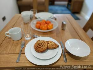 a wooden table with a plate of food on it at Central Nottingham Gem - Luxurious 2-Bed Apartment in Nottingham