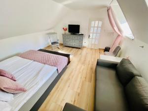 a bedroom with a bed and a couch at Várárok Vendégház - Miskolc in Miskolc