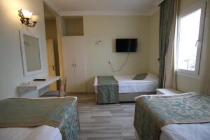 ボドルム・シティにあるArtemis Hotelのベッド2台とテレビが備わるホテルルームです。