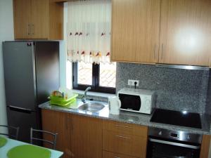 a kitchen with a sink and a microwave at Casa do Mosteiro de Refoios do Lima in Ponte de Lima