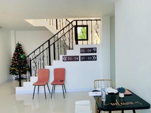 a dining room with two chairs and a christmas tree at KONG INN Renunakhon in Renu Nakhon