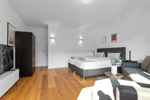 een slaapkamer met een bed en een bank bij Flatista Homes - Hirschgarten in München