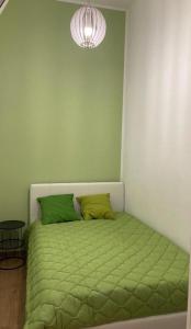 a bed with two green pillows in a room at Casa Vacanze al Trenta3 in Marsala