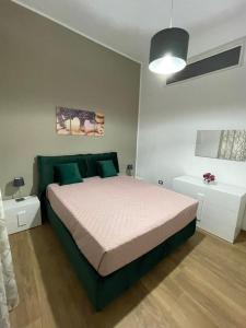 a bedroom with a large bed with green pillows at Casa Vacanze al Trenta3 in Marsala