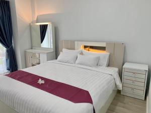 a bedroom with a large white bed with a purple blanket at KONG INN Renunakhon in Renu Nakhon +14 photos