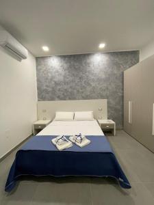ein Schlafzimmer mit einem Bett mit zwei Handtüchern darauf in der Unterkunft B&b 3rooms Chiaia 2 in Neapel