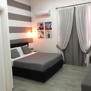 ein Schlafzimmer mit einem Bett und einer gestreiften Wand in der Unterkunft Napoli DownTown in Neapel