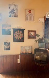 una camera con TV e immagini appese al muro di HÙNG Apartment Dalat a Da Lat