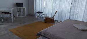 ブラショヴにあるExquisite Apartamentのベッド、テーブル、椅子が備わる客室です。