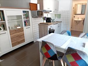 cocina con mesa blanca y sillas en BodenSEE Apartment Meckenbeuren Neuhaldenstrasse, en Meckenbeuren