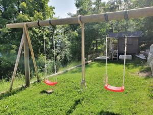 a swing set with three swings in a yard at Heidi in Leysin