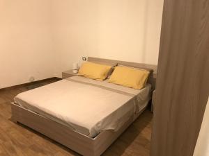 - une chambre avec un lit et 2 oreillers jaunes dans l'établissement Da Piero e Lidia, à Iglesias