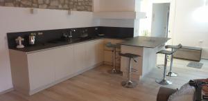 a kitchen with a counter and a sink and stools at CASA DEL LAGO in Travedona