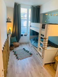 a bedroom with bunk beds in a room with a window at La Loge des Artistes in Honfleur