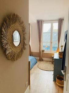 une chambre avec un miroir sur le mur et une chambre dans l'établissement La Loge des Artistes, à Honfleur