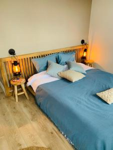 a bedroom with two beds with blue sheets and a lamp at La Loge des Artistes in Honfleur