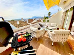 un patio con una parrilla con mesa y sillas en Espectaculares vistas a África y Gibraltar en Málaga