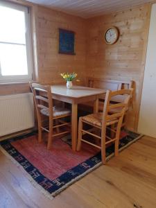 a dining room with a table and chairs and a clock at Gemütliche Wohnung in Einfamilienhaus in Alberschwende