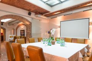 una sala de reuniones con una mesa y una pantalla de proyección en Hotel Marc Aurel - Vienna City Center, en Viena