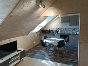 a kitchen with a table and chairs in a room at Grand T2 proche canal de Nantes à Brest. in Châteauneuf-du-Faou