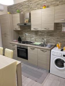 a kitchen with a sink and a washing machine at Lo Scalo Apartment in Molfetta