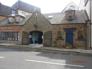an old brick building on the corner of a street at The Folly Hotel in North Berwick