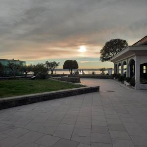 a sunset over the ocean with a building and a sidewalk at Apartment Kristjan in Portorož +7 photos